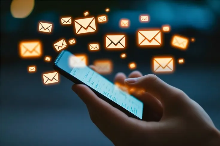 Hand holding phone with emails